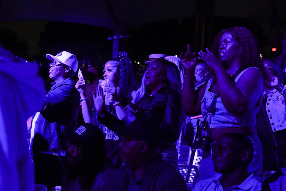 Fans sing along under blue stage light